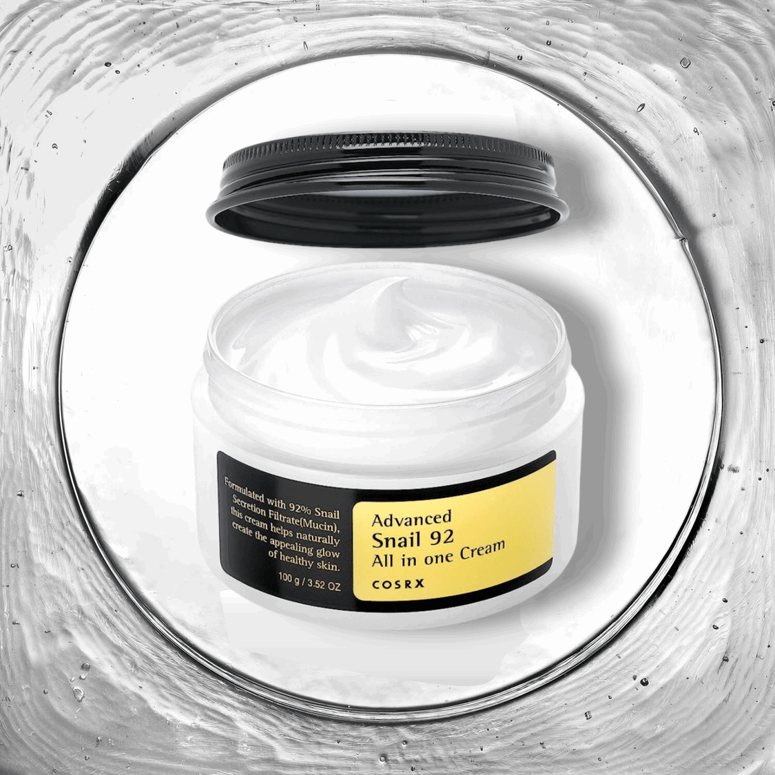 Image de 'Advanced Snail 92 All In One Cream' de COSRX, présentée dans un pot rond transparent avec un couvercle noir, posé sur un fond neutre. Cette crème tout-en-un contient 92% de mucine d'escargot, qui hydrate, répare et apaise la peau tout en améliorant sa résilience et sa texture. Parfaite pour les consommateurs au Maroc à la recherche de solutions de soin de la peau multifonctionnelles, disponible sur Beauty-Care.ma.