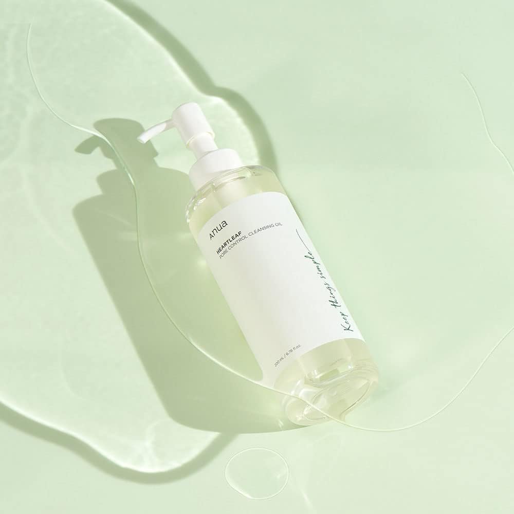 Heartleaf Pore Control Cleansing Oil d'Anua, présenté dans un flacon transparent de 200 ml avec une pompe, capturé sur un fond simple pour mettre en avant l'efficacité du produit dans le nettoyage des pores. Enrichi en extrait de feuille de heartleaf, ce démaquillant doux est idéal pour les peaux sensibles, offrant un soin apaisant et purifiant. Disponible sur Beauty-Care.ma, une référence pour les soins de la peau de qualité au Maroc.