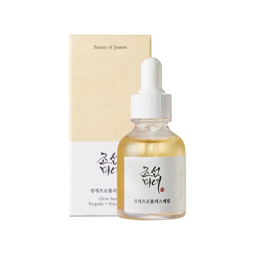 Image du 'Glow Serum - Sérum Éclat propolis + niacinamide' de Beauty of Joseon, présenté dans un flacon compte-gouttes transparent avec des détails en or, sur un fond lumineux et doux. Ce sérum combine la propolis et la niacinamide pour hydrater, illuminer et améliorer la clarté de la peau, tout en réduisant les rougeurs et les imperfections. Idéal pour les utilisateurs au Maroc cherchant à revitaliser leur teint, disponible sur Beauty-Care.ma.